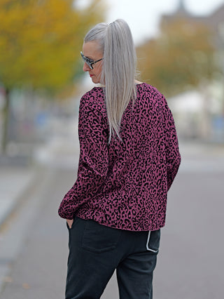 Frau mit grauen Haaren trägt eine Sonnenbrille und das OFF#DLY Shirt Cindy burgundy mit langem Ärmel und Allover Leo Flockprint, während sie draußen steht.