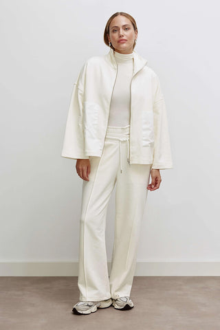Frau trägt das Cotton Candy Liz Sweat, ein oversized Sweatjacke mit Troyer Kragen und aufgesetzten Webtaschen, ideal für vielseitige Kombinationen. Perfekt für modebewusste Outfits.