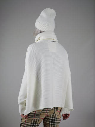 Eine Person trägt den Philomena Ripp Pulli FEAT weiß, ein leichter, boxy geschnittener Ripp-Pullover mit weißem Strickmuster, kombiniert mit einem passenden Hut.