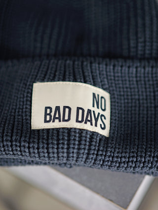 Halsüberkopf Mütze No bad Days marina aus 100% Bio-Baumwolle, mit einem weißen Label mit schwarzem Text auf der Vorderseite.