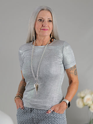 OFF#DLY Top Sindy grau/silber, getragen von einer Frau, mit Feinstrick und silbernem Lurex-Faden, Rundhals-Design. Sichtbare Details: eng anliegend, schmaler Schnitt.