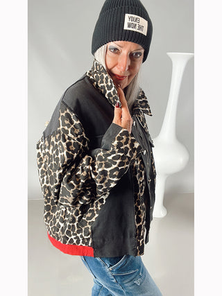 OFF#DLY National Jacket black/leo – Frau trägt eine coole, oversized Jacke mit Leoprint, roten Bündchen, aufgesetzten Taschen und verdeckter Knopfleiste. Rückenprint NATIONAL und Kordelzug am Bund sichtbar.