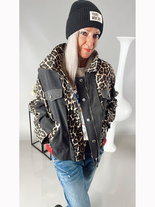 Frau trägt die OFF#DLY National Jacket black/leo, eine oversized Jacke mit Leoprint, roten Bündchen, aufgesetzten Taschen, verdeckter Knopfleiste und Zipper, passend für Größen 36 bis 44.