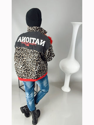 OFF#DLY National Jacket black/leo: Oversized Jacke mit Leoprint, rotem Bund, aufgesetzten Taschen und verdeckter Knopfleiste. Modell trägt blaue Jeans und schwarze Stiefel.
