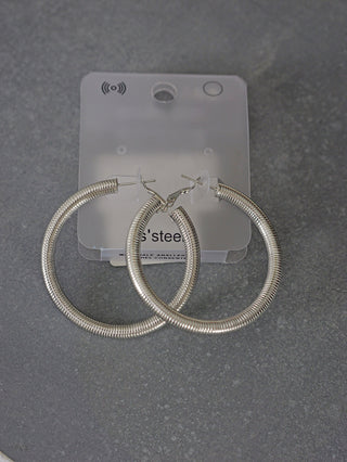 OFF#DLY Ohrschmuck ROUND: Edelstahl-Ohrringe in runder Form mit Federn-Design, präsentiert auf einem Plastiksockel. Größe etwa 5 cm, ideal als modisches Accessoire.