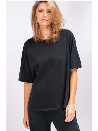 True Religion Boxy Crew Tee black: Frau im locker geschnittenen, schwarzen T-Shirt aus 100% Baumwolle mit kurzen Ärmeln, modisch lässig getragen. Ideal für einen entspannten, stilvollen Auftritt.