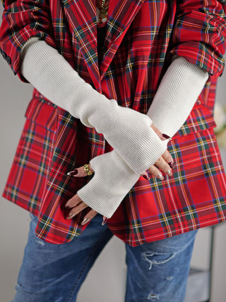 Person trägt OFF#DLY Stulpe offwhite mit Daumenöffnung, kombiniert mit kariertem Hemd und weißen Handschuhen. Die Armstulpe besteht aus Acryl, Viskose und Wolle und ist in Einheitsgröße erhältlich.