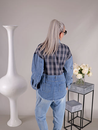 Eine Frau trägt die OFF#DLY Denimbluse Clara, eine sportive Jackenbluse mit Karomuster, Knopfleiste und Brusttaschen, während sie vor einer Vase mit weißen Rosen steht.