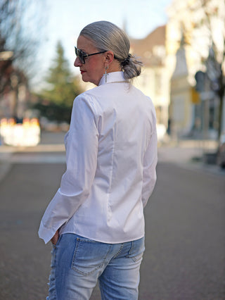 OFF#DLY Slimfit Bluse Tina white, getragen von einer Frau mit grauen Haaren und Sonnenbrille, zeigt eine schmale, gerade Passform und Knopfleiste, geeignet für lässige Street-Fashion.