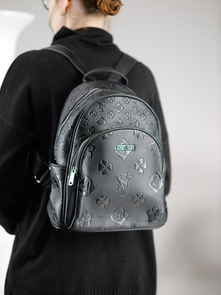 Eine Person trägt den Sweet Years Rucksack mid schwarz; ein stilvoller Rucksack mit geprägten Designs, verstellbaren Trägern und mehreren Reißverschlussfächern, perfekt als modisches Accessoire.