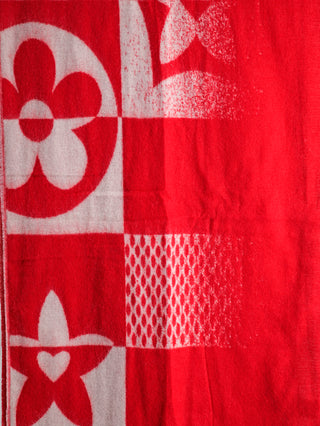 Das Bild zeigt den OFF#DLY Schal Adelina rot/weiß, ein weiches, großes Textil mit vierteiligem Schachbrettmuster und floralen, sternförmigen sowie abstrakten Motiven in rot und weiß.