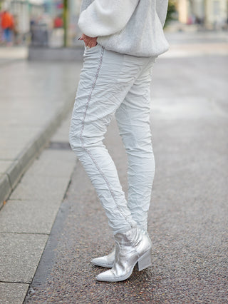 Person trägt OFF#DLY Pant Tina grey, eine leichte Joggpant mit Gummibund und seitlicher Kettenkordel, kombiniert mit silbernen Schuhen.