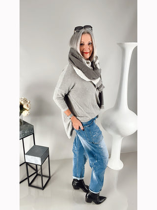 OFF#DLY Denim Viviana midblue Boyfriend-Jeans mit aufgesetzten Taschen und Kordelgürtel, getragen von einer Frau in grauem Shirt und schwarzem Stiefel, sitzend auf einem Metallrahmenstuhl.