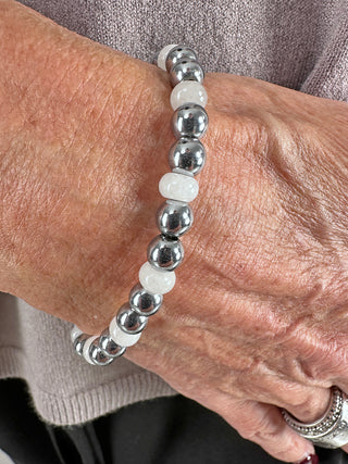 Nahaufnahme eines Handgelenks, das das Glam & Rock Armband Edelstahl weiß trägt, ein elastisches Armband aus Edelstahl und Edelstein mit einem Durchmesser von ca. 5 mm.