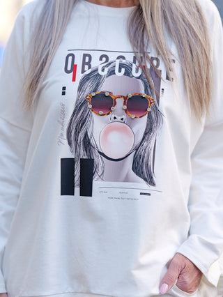 Person trägt OFF#DLY Sweat obscure white, ein weißes Rundhalssweatshirt mit glitzerndem Print einer Frau mit Sonnenbrille und Bubblegum. Modell ist 172 cm groß, passt bis Größe 44.