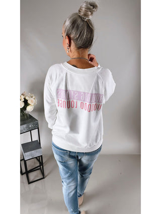 Frau trägt Recycled Karma Tee Rolling Stones Voodoo, weißes T-Shirt mit lässiger Passform und Voodoo Lounge-Design, steht vor weißer Wand.
