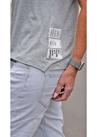 Person trägt das Liv Bergen Top EAST Melange, ein graues Rundhals-Shirt mit kleinen Patches, aus 67% Tencel und 33% Baumwolle, passend in Größe M bei 172 cm Körpergröße.