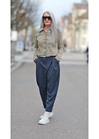 OFF#DLY Jacke Fiola beige im Denim-Stil, getragen von einer Frau mit grauem Haar und Sonnenbrille, schmal geschnitten, kombiniert mit blauen Hosen und weißen Schuhen.