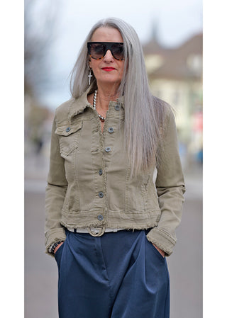 Frau mit grauen Haaren trägt OFF#DLY Jacket Fiola beige, Denim-Stil, schmale Passform, sichtbare Taschen und Knöpfe, modisch mit Sonnenbrille kombiniert.