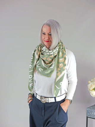 Frau mit grauem Haar trägt das OFF#DLY Tuch LOVE khaki, ein gemustertes Musselintuch aus 100% Baumwolle. Größe ca. 195x95 cm. Perfekt als modisches Accessoire für kühlere Tage.