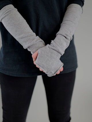 Person trägt OFF#DLY Stulpe grau, mit grauem Handschuh sichtbar. Materialmix aus Viskose, Nylon, Polyester sorgt für Komfort. Einheitsgröße. Produkt von G+K Group, Italien.
