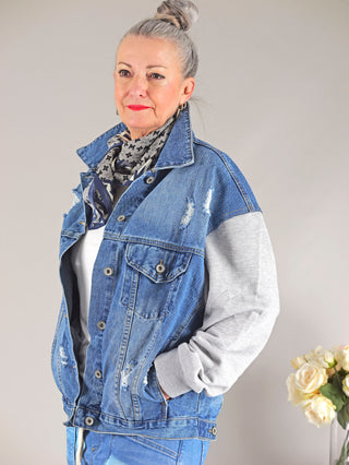Eine Frau trägt das OFF#DLY Tuch Verona taupe mit allover Print, aus feiner Viskose, Größe 50x50cm, sichtbar unter einer Jeansjacke.