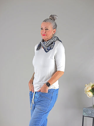 Frau mit grauen Haaren trägt das Cotton Candy Tee Bale white mit Rundhals, längerer Schnitt, kombiniert mit einem Schal.