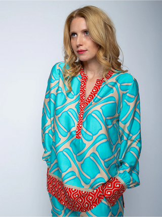 Emily Bluse coral/border 8484-155950, getragen von einer Frau, zeigt ein süßes Design mit kleinem Kragen, V-Ausschnittblende und langen Ärmeln mit Manschette auf Viskose Satin.