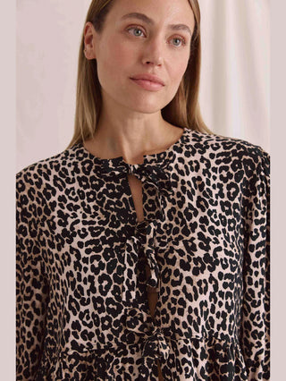 Cotton Candy Bluse Mina Multicolor: Frau trägt lässige Kurzarmbluse mit Leoprint, Schnürung vorne und Puffärmeln. Perfekt für einen stilvollen, entspannten Look.