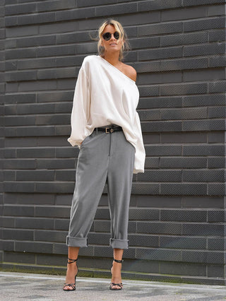 Gitta Banko Hose Margaux grey, getragen von einer Frau mit weißem Shirt und Sonnenbrille. Die Hose ist gerade geschnitten, verkürzt, mit seitlichen Einschubtaschen und wirkt lässig-elegant.