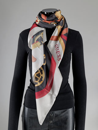 Frau trägt Guess Tuch Foulard IVM, ein quadratisches Tuch aus Polyester mit Ketten-, Gürtel- und Schloss-Print. Maße 125x125 cm. Ideal als modisches Accessoire.