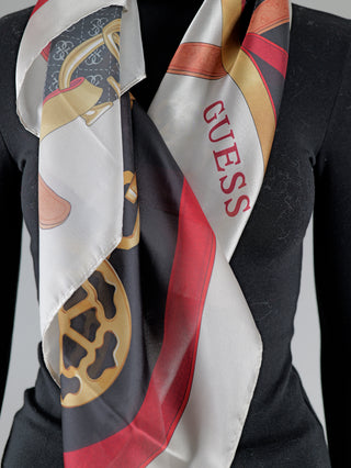 Frau trägt Guess Tuch Foulard IVM aus Polyester, quadratisch mit Ketten- und Gürteldruck sowie 4G-Logo, 125x125 cm.