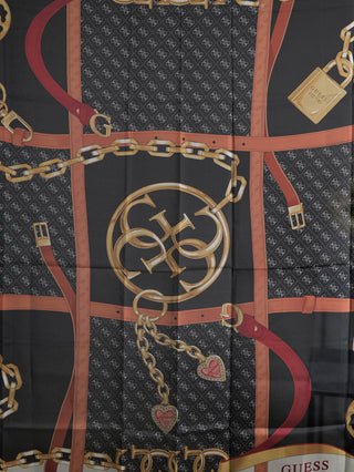 Guess Tuch Foulard IVM mit goldenen Ketten, Gürteln und 4G-Logo auf schwarzem Hintergrund, quadratisch, 125 x 125 cm aus 100% Polyester.