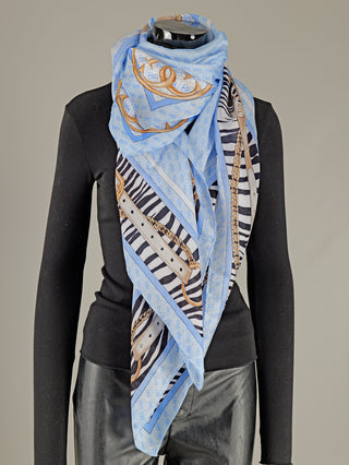 Guess Zamira Foulard LBU: Ein quadratisches Tuch aus Viskose, auf einem Schaufensterpuppenmodell gezeigt, mit Animalprint, Gürteln und 4G-Logo, das Modeaccessoire betont. Maße 130 x 130 cm.