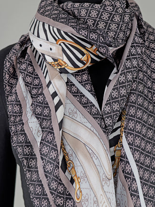 Guess Zamira Foulard CLO auf einer Schaufensterpuppe, quadratisches Tuch aus Viskose mit Animalprint und Gürteldetails, 4G-Logo, Maße 130 x 130 cm.