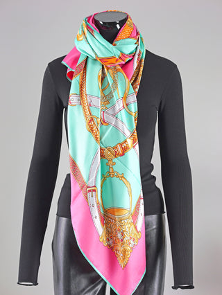 Mannequin trägt OFF#DLY Schal Crown pink/türkis, ein gemustertes Tuch aus Viskose, Größe ca. 130x130 cm. Ideal als modisches Accessoire für vielfältige Stylings.
