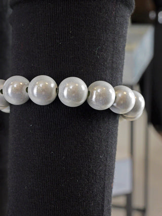 OFF#DLY Kugelarmband 12mm grey Magic aus Acryl, präsentiert auf schwarzer Oberfläche. Naheaufnahmen zeigen perlenartige Details, die das Armband als elegantes Modeschmuckstück hervorheben.