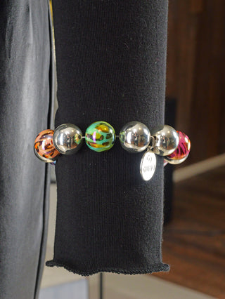 Kugelarmband OFF#DLY 15 mm multi Leo mit glänzenden Perlen im Leomuster und silbernen Kugeln auf schwarzem Hintergrund. Freie Größe, aus Acryl.