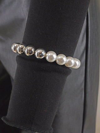 OFF#DLY Kugelarmband 9 mm silber/weiß, präsentiert auf schwarzer Oberfläche, zeigt glänzende Perlen in silber und weiß. Hergestellt aus Kupfer und Acryl, freigrößig und elegant designt.