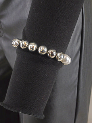OFF#DLY Kugelarmband 9 mm silber/weiß, ein elegantes Armband aus glänzenden Silber- und weißen Perlen, getragen auf einem schwarzen Ärmel, ideal als stilvolles Modeaccessoire.