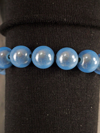 OFF#DLY Kugelarmband 9 mm blue Magic, ein Armband aus blauen Acrylperlen mit magischem Glanz, auf schwarzem Untergrund präsentiert. Freie Größe, Gewicht 19 g, ein elegantes Modeaccessoire.