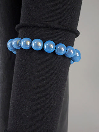 OFF#DLY Kugelarmband 9 mm blue Magic: Ein blaues Perlenarmband auf schwarzem Untergrund, bestehend aus glänzenden Acrylperlen, als stilvolles Modeaccessoire.