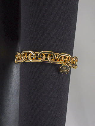 OFF#DLY Gliederarmband gold, ein glänzendes Aluminiumarmband mit Kettengliedern, liegt auf schwarzem Stoff. Hochglanzbeschichtung verleiht ihm einen eleganten, modischen Look.