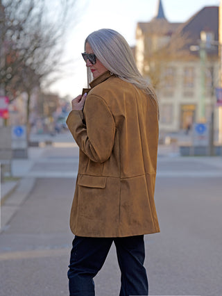 Frau trägt OFF#DLY Blazer Lin braun, stilvoller Longblazer aus Kunstleder in Wildlederoptik, mit zwei Knöpfen und seitlichen Taschen, passend zu Street-Fashion.