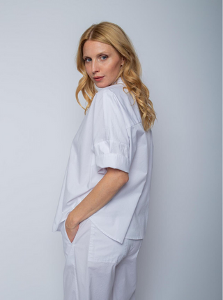 Emily Bluse 4890-154971 lightblue: Frau trägt weiße Hemdbluse mit modernen Halbarmlängen und Knopfleiste, lockere Oversize-Passform, weiche Baumwoll-Elasthan-Mischung.