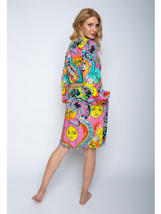 Emily Kleid 8503-156491 pink / comic zeigt eine Frau in einem farbenfrohen Kleid mit V-Ausschnitt und Stehkragen, Gürtel aus Deko Tape und Manschettenärmeln, passend für Größe 36.