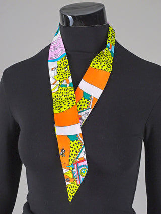 Mannequin trägt das OFF#DLY Kleines Tuch multicolor, ein modisches Accessoire aus 100% Polyester, ideal für Handgelenk oder Haare. Maße: ca. 90 x 5 cm.