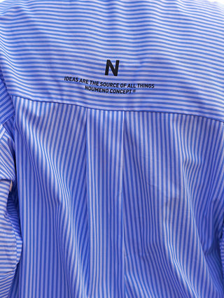 Nuomeno Concept Bluse Corta bianco: Eine blau-weiß gestreifte Boxy-Bluse mit weiten 3/4-Ärmeln, Knopfleiste und großer Brusttasche, getragen von einer Person.