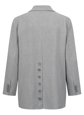 Gitta Banko Blazer Alison grey, ein zweireihiger grauer Blazer mit auffälliger Knopfleiste hinten und seitlichen Taschen, oversized Passform. Perfekt für stilvolle Auftritte.
