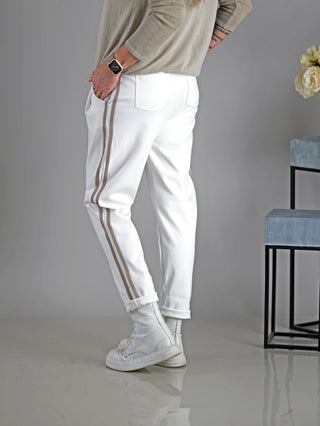 Eine Person trägt die OFF#DLY Hose Mirella offwhite mit Gummibund und Kordelzug, kombiniert mit weißen Stiefeln. Die Hose hat seitliche Taschen und eine gerade Passform.